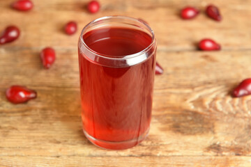 Glass of tasty dogwood drink on wooden background, closeup