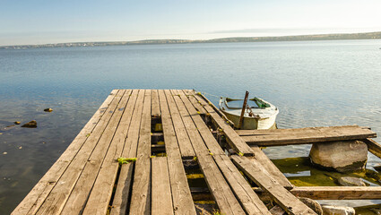 Fototapeta premium A wooden bridge with a submerged boat on the lake.