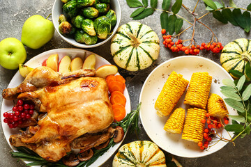 Tasty baked turkey and different food for Thanksgiving Day on grunge background