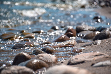 Seashore with rocks and bokeh sparkling blue water