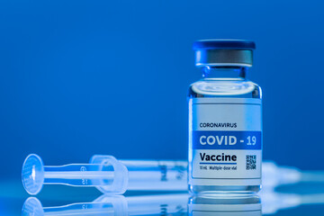 Covid vaccine with syringe on blue background