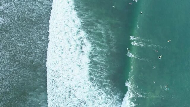 Amazing aerial view Top down of waves break on tropical sea Surfers with surfing boards Aerial drone view 4-k shot of sea waves on the beautiful ocean at Phuket Thailand