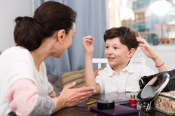 Portrait of happy tweenager having friendly chat with his mom at home..