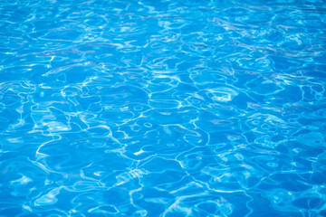 Fototapeta na wymiar Water background, ripple and flow with waves. Summer blue swiming pool pattern. Sea, ocean surface. Overhead top view with place for text.