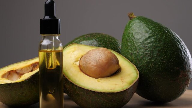 Avocado oil with avocado fruit on wooden table. Avocado is a highly nutritious fruit.	