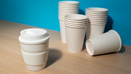 ZERO WASTE: One reusable mug and a many paper cups on a table - 460215198