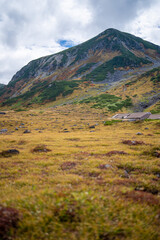 富山県立山町の立山の秋の紅葉の季節に登山している風景 Scenery of climbing Tateyama Mountain in Tateyama Town, Toyama Prefecture, Japan during the season of autumn leaves. 