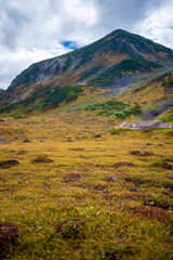 富山県立山町の立山の秋の紅葉の季節に登山している風景 Scenery of climbing Tateyama Mountain in Tateyama Town, Toyama Prefecture, Japan during the season of autumn leaves. 