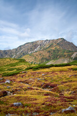 富山県立山町の立山の秋の紅葉の季節に登山している風景 Scenery of climbing Tateyama Mountain in Tateyama Town, Toyama Prefecture, Japan during the season of autumn leaves. 