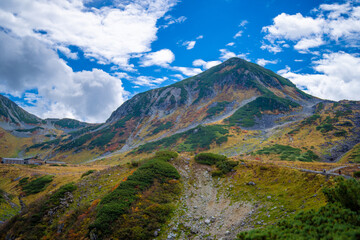 富山県立山町の立山の秋の紅葉の季節に登山している風景 Scenery of climbing Tateyama Mountain in Tateyama Town, Toyama Prefecture, Japan during the season of autumn leaves. 