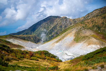 富山県立山町の立山の秋の紅葉の季節に登山している風景 Scenery of climbing Tateyama Mountain in Tateyama Town, Toyama Prefecture, Japan during the season of autumn leaves. 