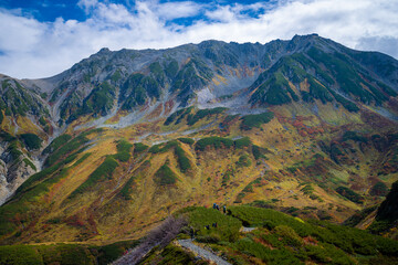 Obraz premium 富山県立山町の立山の秋の紅葉の季節に登山している風景 Scenery of climbing Tateyama Mountain in Tateyama Town, Toyama Prefecture, Japan during the season of autumn leaves. 