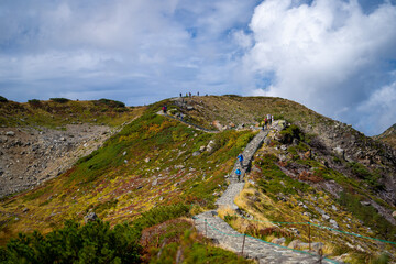 富山県立山町の立山の秋の紅葉の季節に登山している風景 Scenery of climbing Tateyama Mountain in Tateyama Town, Toyama Prefecture, Japan during the season of autumn leaves. 