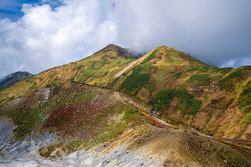 富山県立山町の立山の秋の紅葉の季節に登山している風景 Scenery of climbing Tateyama Mountain in Tateyama Town, Toyama Prefecture, Japan during the season of autumn leaves. 