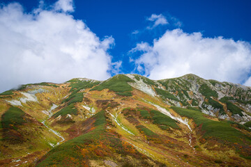 富山県立山町の立山の秋の紅葉の季節に登山している風景 Scenery of climbing Tateyama Mountain in Tateyama Town, Toyama Prefecture, Japan during the season of autumn leaves. 
