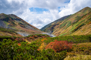 富山県立山町の立山の秋の紅葉の季節に登山している風景 Scenery of climbing Tateyama Mountain in Tateyama Town, Toyama Prefecture, Japan during the season of autumn leaves. 