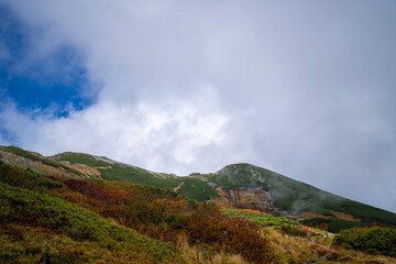 富山県立山町の立山の秋の紅葉の季節に登山している風景 Scenery of climbing Tateyama Mountain in Tateyama Town, Toyama Prefecture, Japan during the season of autumn leaves. 