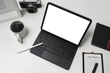 Mock up computer tablet, coffee cup and camera on white table.