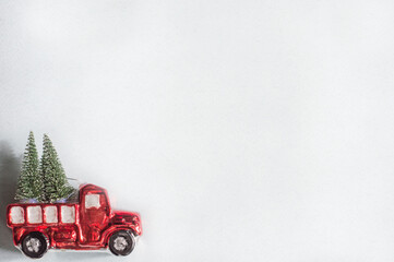 Retro red pickup truck toy with Christmas trees on a textured blue background. Christmas template.