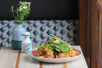 deep-fried chicken wings in breadcrumbs and fresh vegetable close-up on a plate. horizontal top view from above