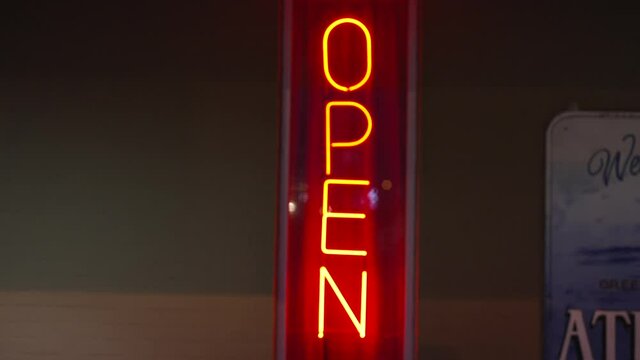 This video features a strobing red neon "open" sign at night.