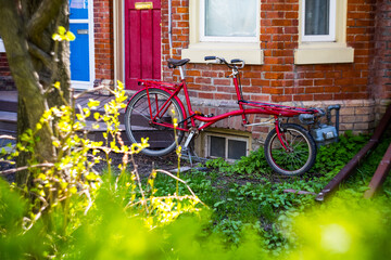 Fototapeta na wymiar Red Bike In Front of City House