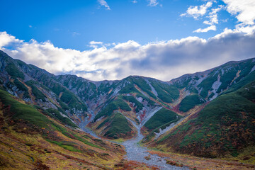 富山県立山町の立山の秋の紅葉の季節に登山している風景 Scenery of climbing Tateyama Mountain in Tateyama Town, Toyama Prefecture, Japan during the season of autumn leaves. 