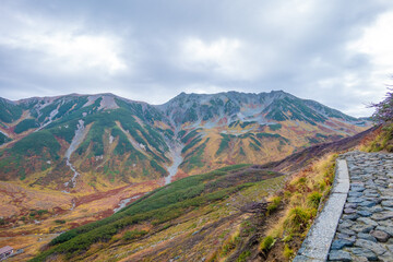 富山県立山町の立山の秋の紅葉の季節に登山している風景 Scenery of climbing Tateyama Mountain in Tateyama Town, Toyama Prefecture, Japan during the season of autumn leaves. 
