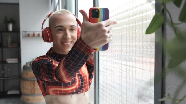 young non binary model using smartphone for videoconference at work