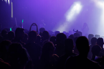 Fototapeta premium Silhouette of Crowd of people in concert with colorful lights in background. Concert concept 