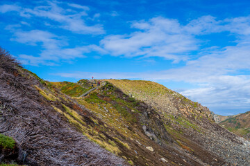 富山県立山町の立山の秋の紅葉の季節に登山している風景 Scenery of climbing Tateyama Mountain in Tateyama Town, Toyama Prefecture, Japan during the season of autumn leaves. 
