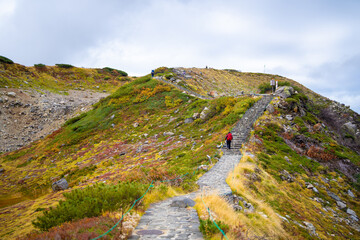 富山県立山町の立山の秋の紅葉の季節に登山している風景 Scenery of climbing Tateyama Mountain in Tateyama Town, Toyama Prefecture, Japan during the season of autumn leaves. 