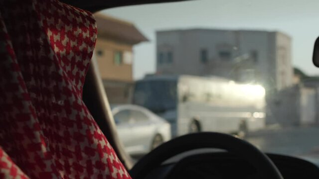 Saudi man inside the car, driving around the city wearing the traditional dress 4K