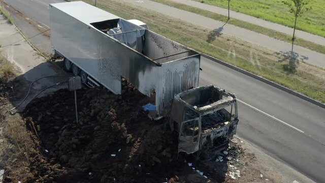 From close-up of burned truck to high altitude. Showing damage from above and traffic next to car.