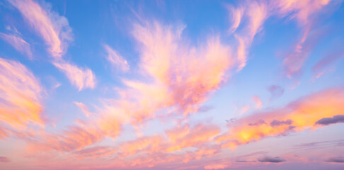 Stunning romantic and relaxing sunrise with some pink illuminated clouds moving across a blue sky....