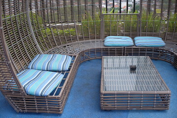 Relaxed seating with beautiful colored foam on unique table chair furniture made of rattan and placed in an open area.