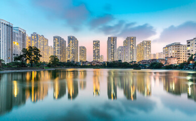 Fototapeta na wymiar Building reflection on water during blue hour. Times city Hanoi. Wallpaper. High quality