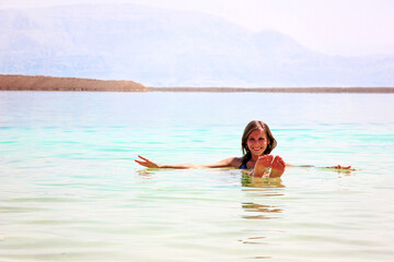 Girl is relaxing floating and swimming in the water of the Dead Sea in Israel. Recreation tourism in Jordan, healthy lifestyle, free time concept