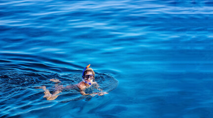 Girl snorkeling in a blue water with circles and ripples. A backdrop of the sea and ocean depth  with copy space