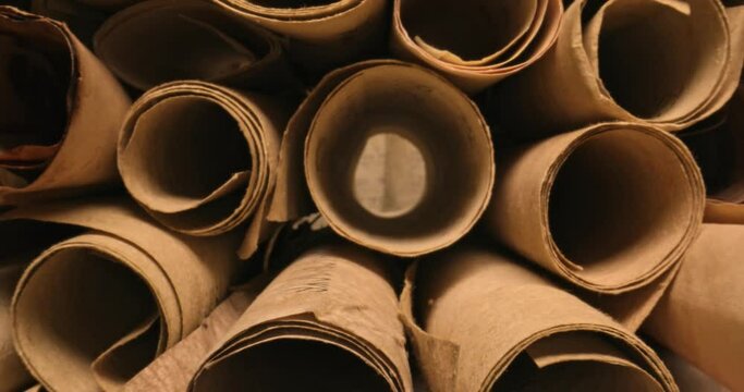 Scrolls with futhpak symbols stacked on pile. Ancient scribe library.