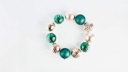 panoramic festive banner. beautiful wreath of Christmas decorations in the form of balls of gold and turquoise on a white background. flat layout with copy space