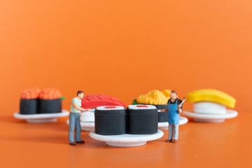 Miniature people ,Chef making Sushi set on orange background