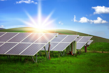 Energy storage system. Photovoltaics solar panels in power station, alternative energy from the sun in field with green grass and mountains at the horizon