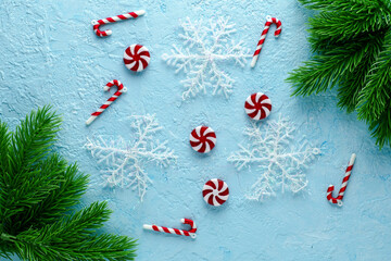 christmas blue background with fir twigs candies and snowflakes