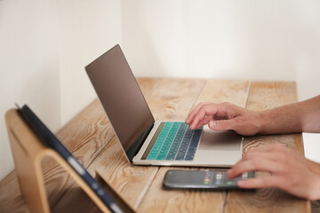 Close-up of a man's hands typing on a keyboard, looking for information. A freelance copywriter is working on a project. The concept of remote work. High quality photo