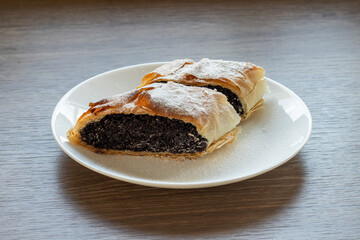 Original Hungarian homemade poppy seed strudel on a white plate