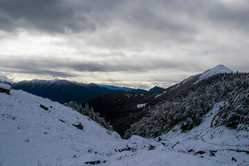 Fototapeta na wymiar Winters mountain range landscape and view, snow and cloudy sky