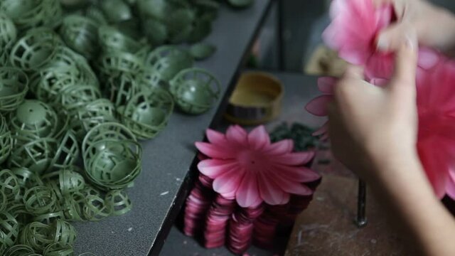 An Enterprise For The Production Of Artificial Flowers. A Woman Folds Plastic Flowers In A Factory.