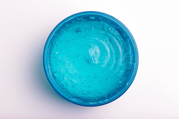 Cosmetic gel in a jar on a white background. Blue transparent gel with texture and bubbles isolate