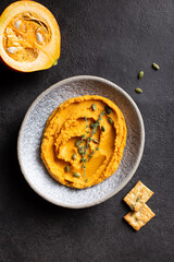 Pumpkin hummus decorated with greens and toasted bread